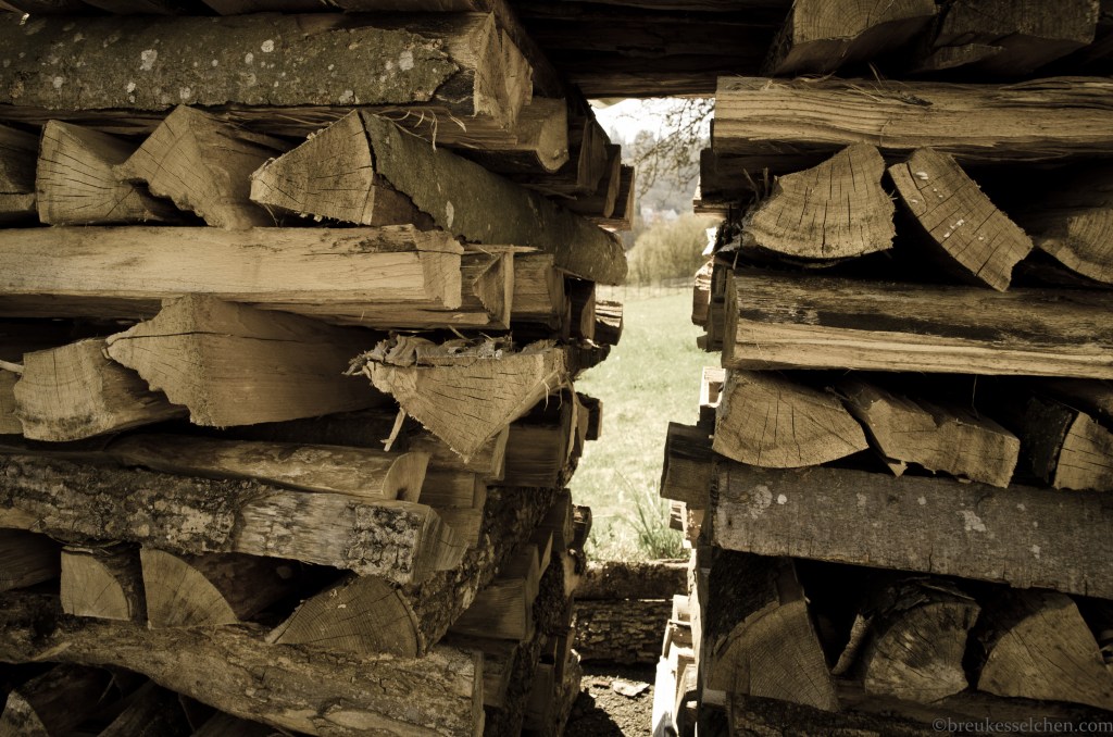 Durchluschern in den Garten...Holzscheiten gestapelt