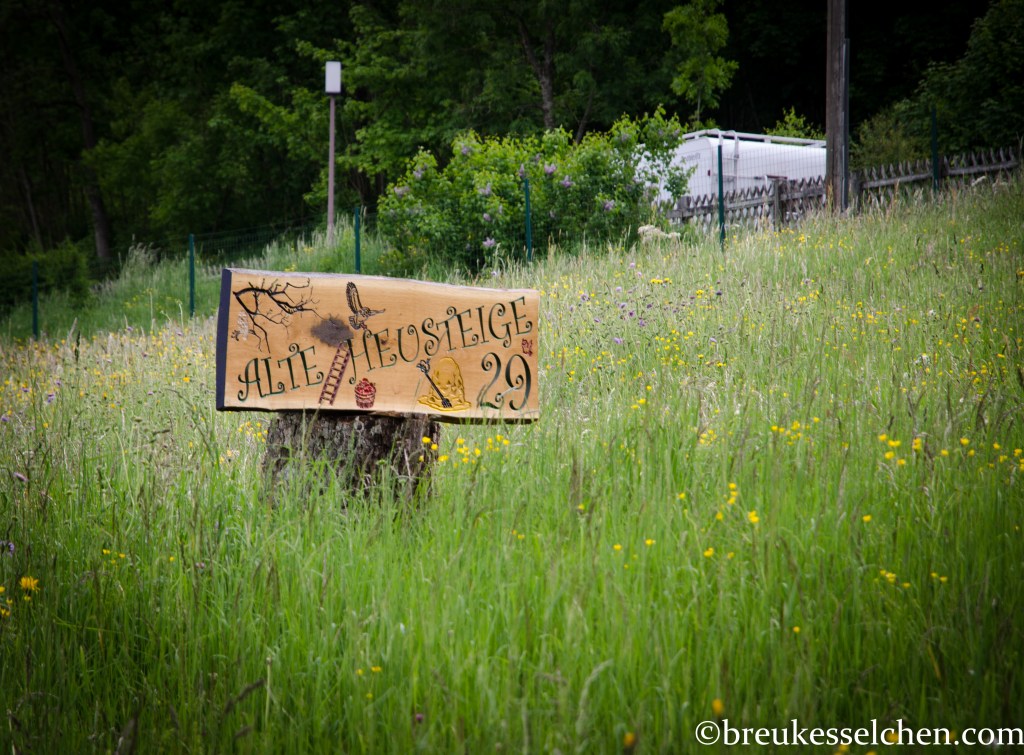 Eichenbrett mit gefräster Beschriftung und gemalten Objekten mit Baumstumpf vereint